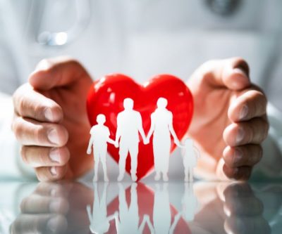 paper cutout of a family with a heart behind them